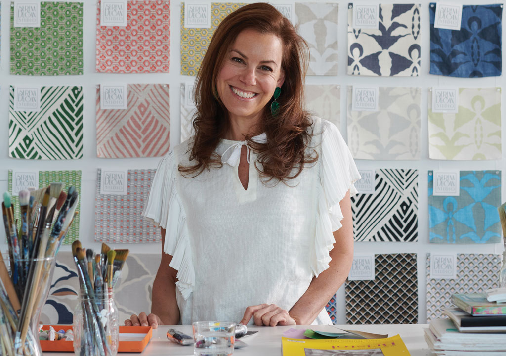 Textile designer Serena Dugan posing with design swatches