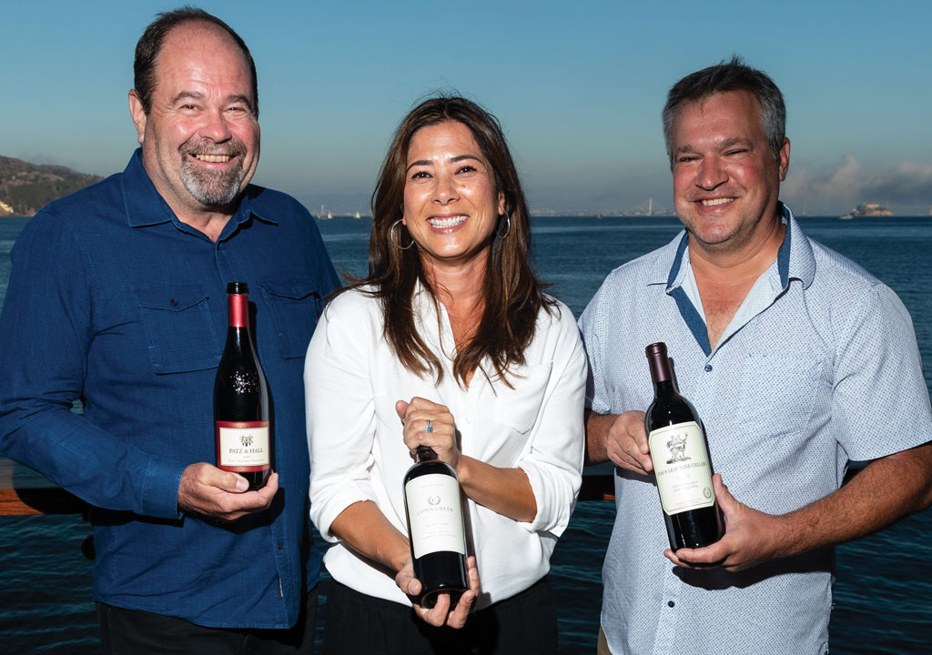 three winemakers holding bottles at Barrel House Tavern