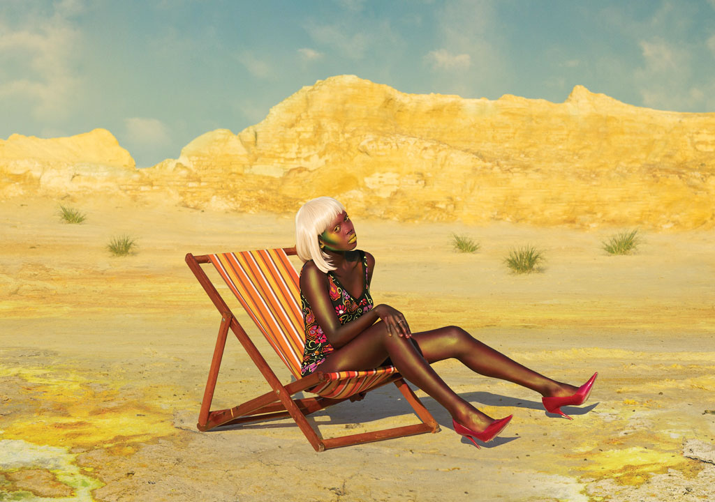 fashionable Black woman sitting in chair in desert