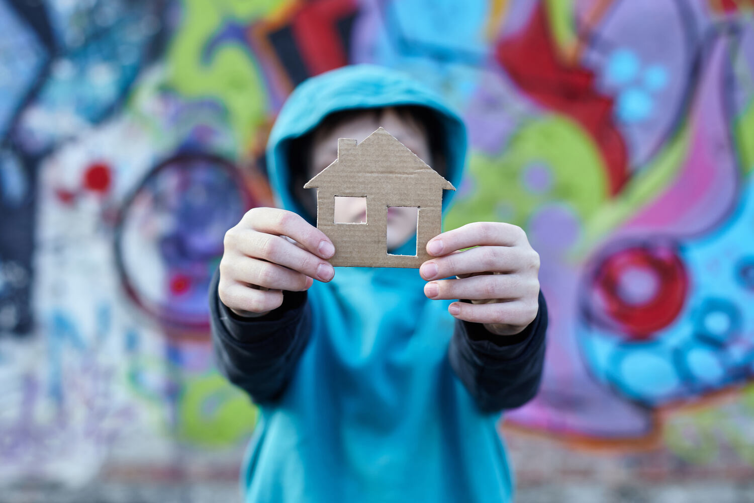 child with small cardboard cutout of house