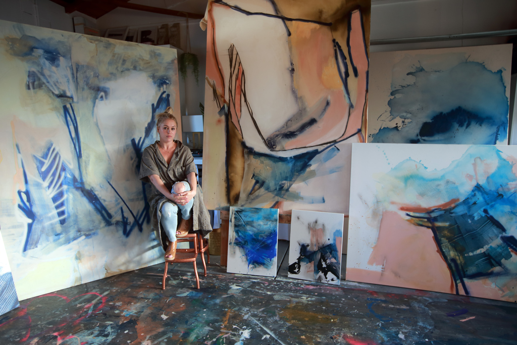 ellie fritz surrounded by paintings