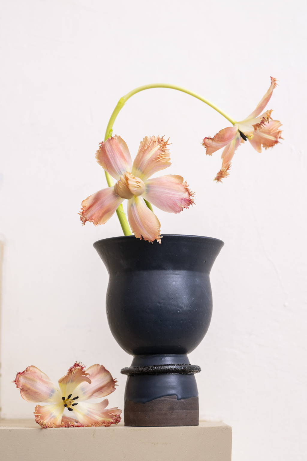 a modern black vase with flowers in it