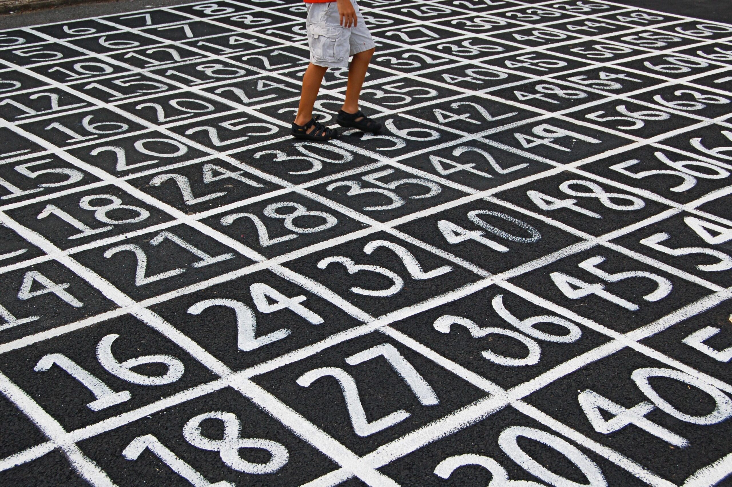 person walking on top of chalk numbers