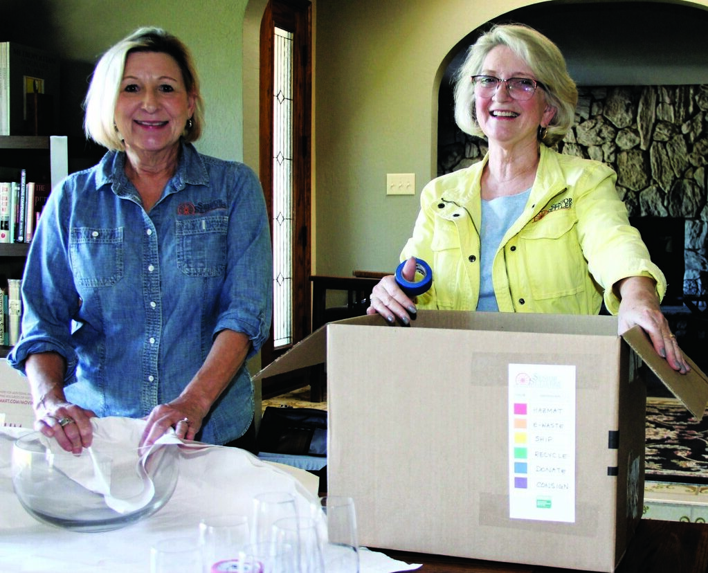 two women packing moving boxes