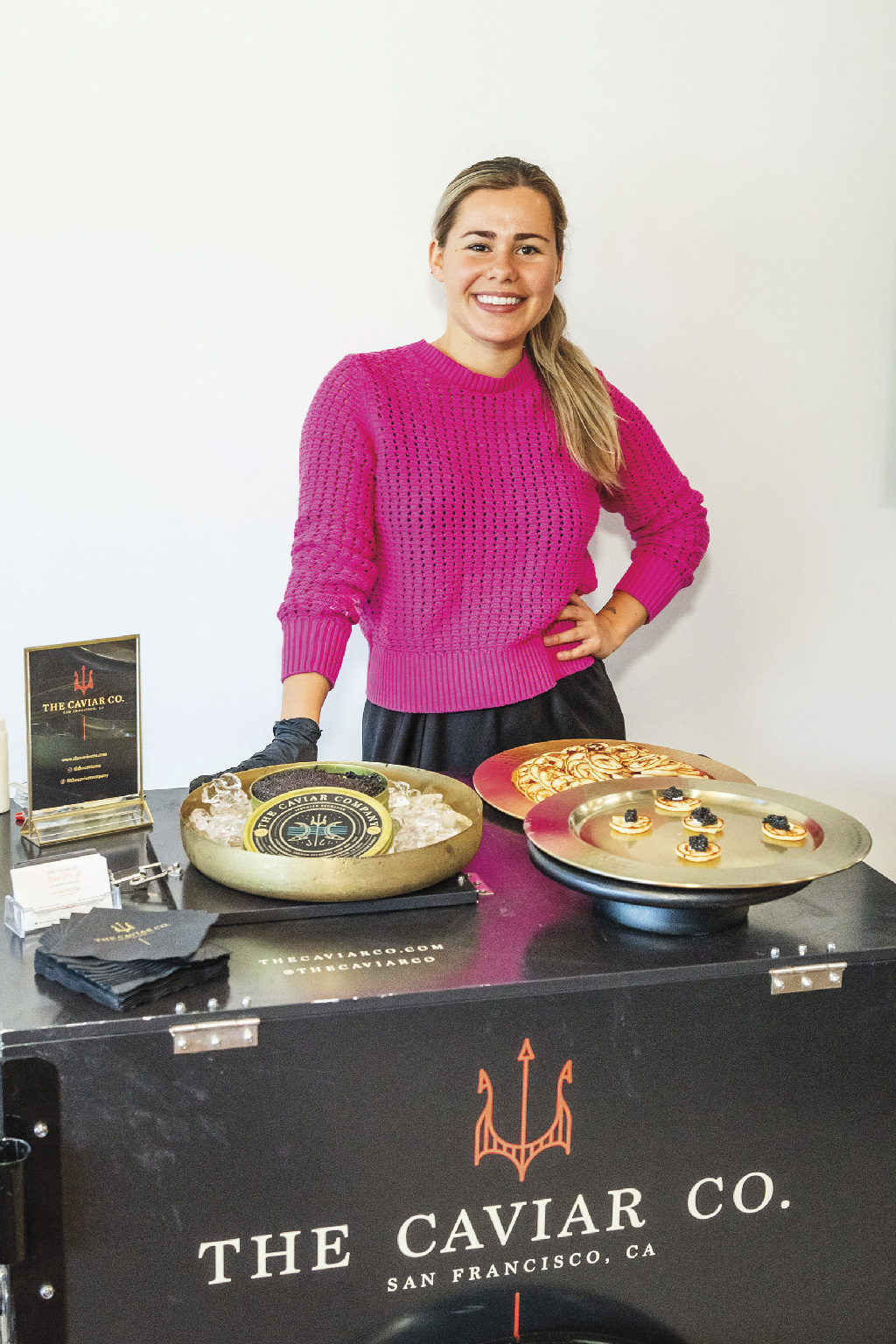 a woman behind The Caviar Co.'s table 