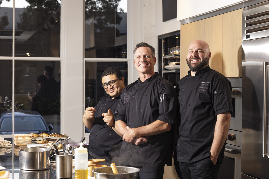 three chefs in a kitchen