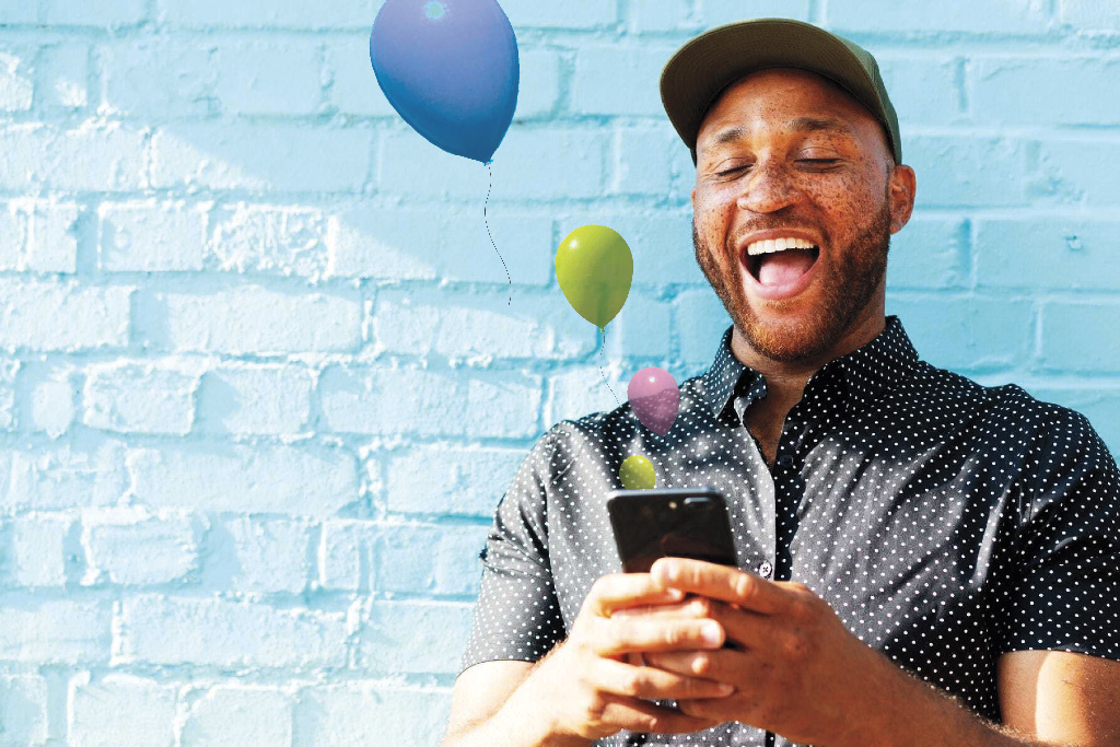 man holding smart phone with balloons coming out of it