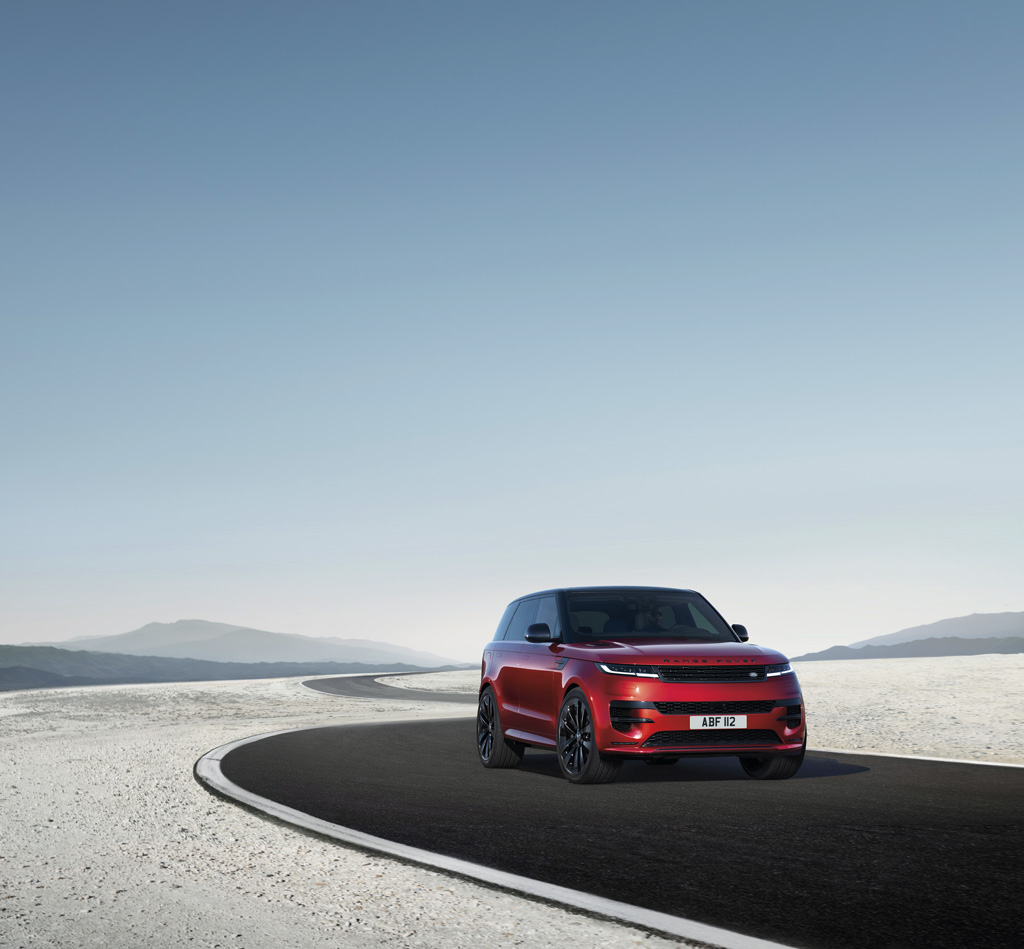 a red range rover sport on a desert road