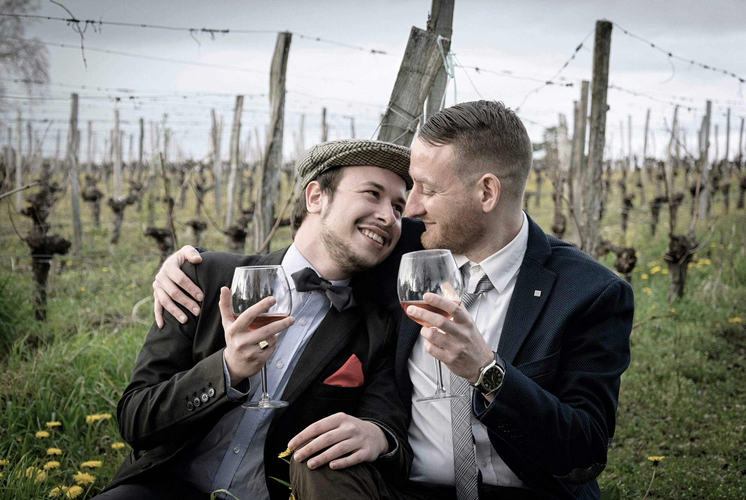 two men drinking wine in a vineyard